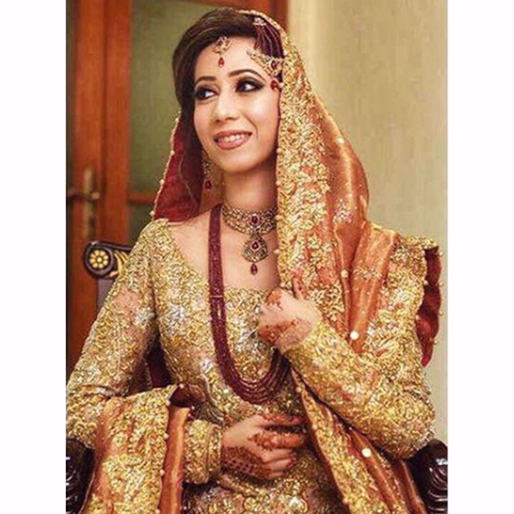 Picture of Shimmering in a regal gold and coral Farah Talib Aziz bridal with hints of bougainvillea and rose pinks