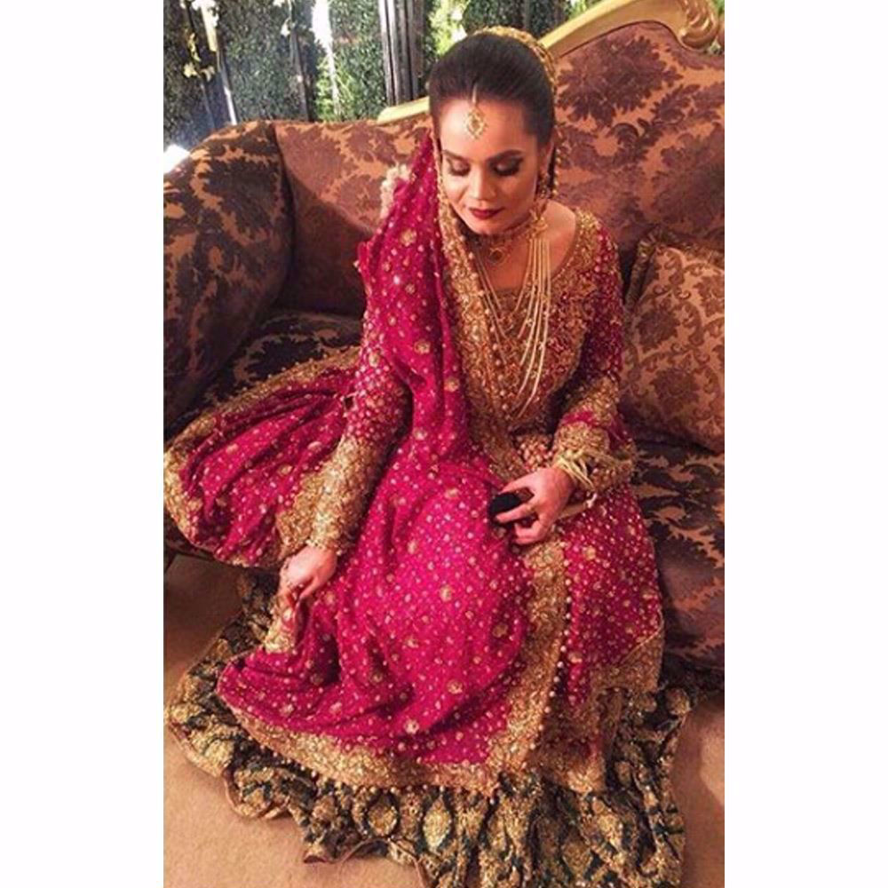 Picture of Sarah, traditionally regal in an anaar red and emerald green Farah Talib Aziz bridal