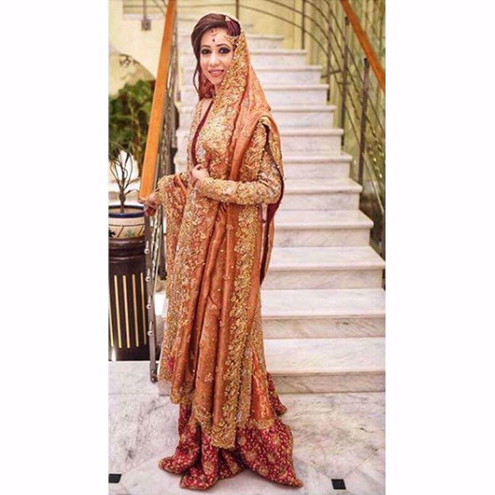 Picture of Samreen, shimmering in a regal gold and coral Farah Talib Aziz bridal