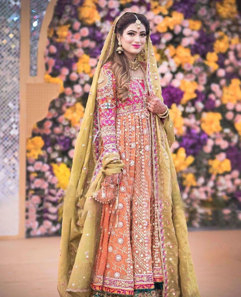 Picture of Nida Gillani at her mehndi in a signature #FarahTalibAziz ensemble. Vivid colours, intricate embroideries and tradtional silhouette, flawlessly come together to create a stunningly regal bridal look