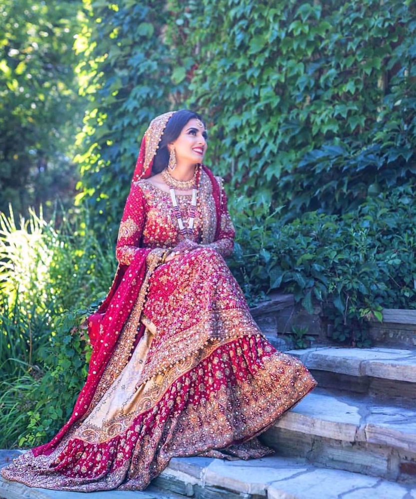 Picture of Farah Talib Aziz gives us a masterclass on how to carry the iconic red bridal. Featured here is a traditional scarlett red ensemble with gold embellishments