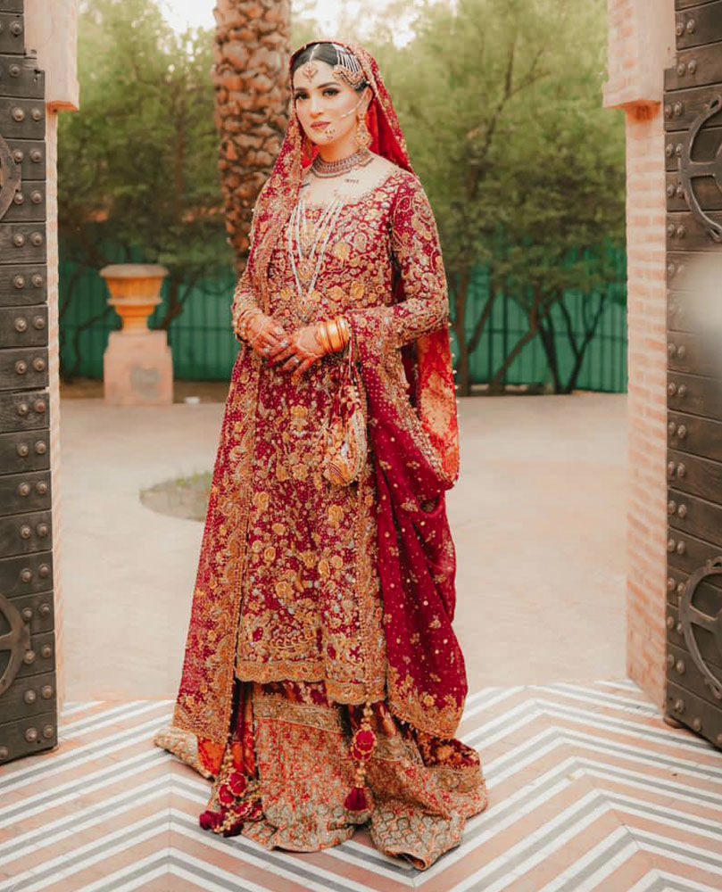 Picture of A BREATHTAKING TRADITIONAL BRIDE ON HER WEDDING DAY IN A CLASSIC RED AND GOLD FARAH TALIB AZIZ SIGNATURE BRIDAL